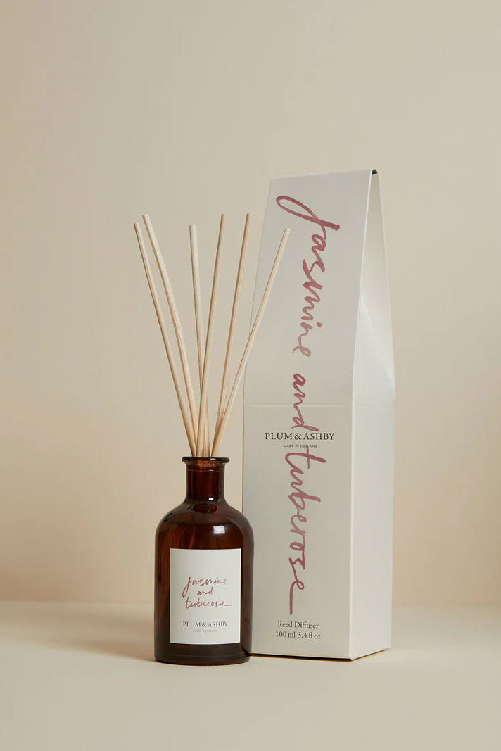 Diffuser bottle with wooden sticks and packaging on a beige background