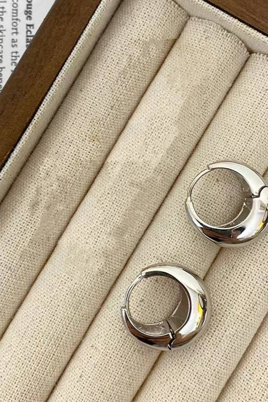 Silver hoop earrings in a jewelry box with fabric lining