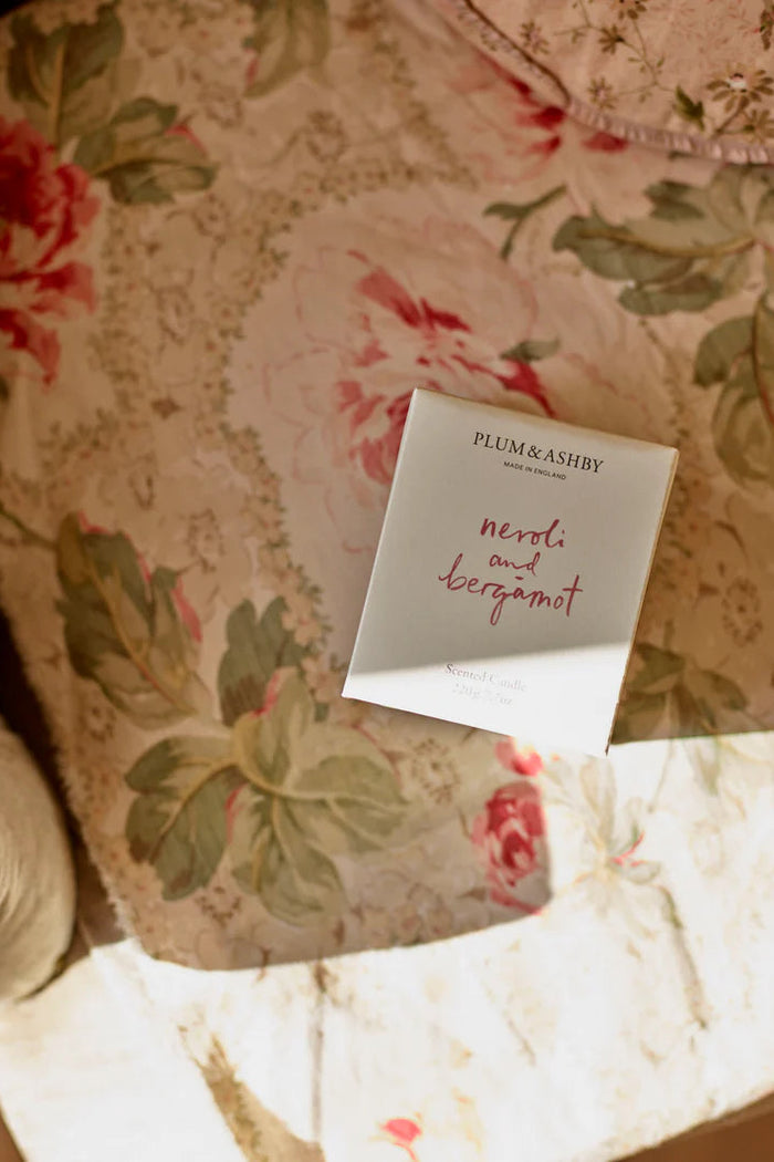 Small product packaging labeled 'Plum & Ashby' on a floral fabric background