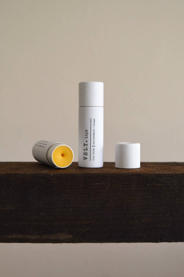 Three cylindrical containers on a wooden surface with a plain background