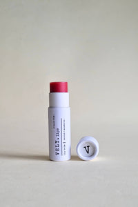 White cylindrical product with red cap and visible branding on a beige background
