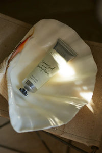 Small bottle of cream on a white cloth with a blurred background
