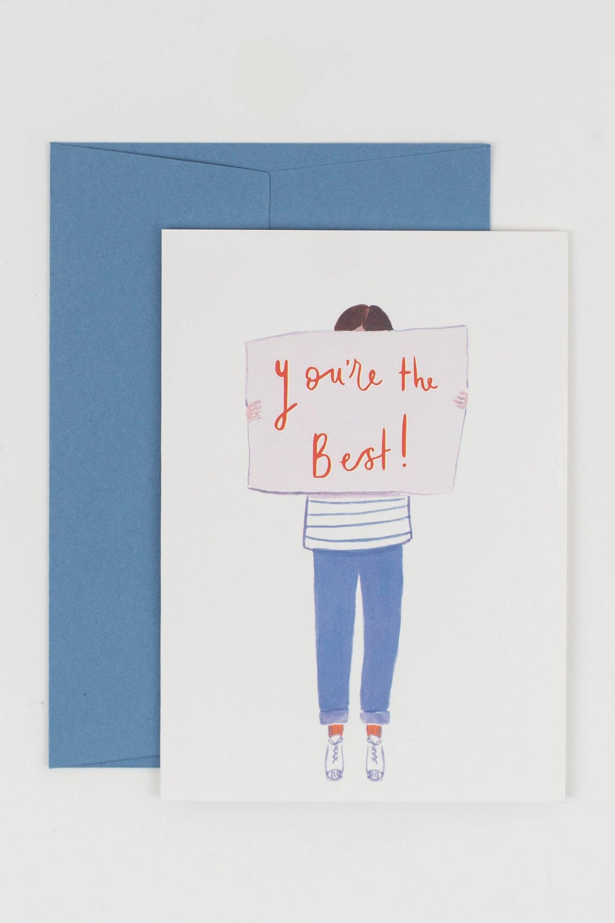 Greeting card with illustration of person holding 'you're the best!' sign, blue envelope