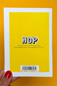 Yellow card with 'HOP' text held against an orange background