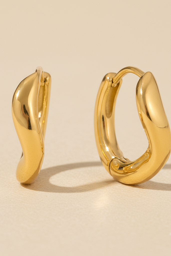 Gold hoop earrings on a beige background
