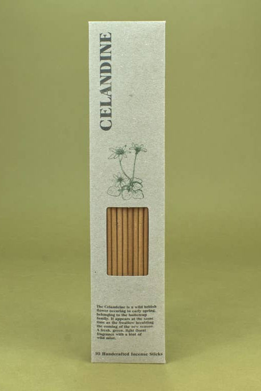A tall, narrow white cardboard box for Oelandine incense sticks, featuring a window that reveals the natural brown incense sticks inside. The box has a minimalist design with a green botanical illustration and the brand name 'OELANDINE' printed vertically on the side.