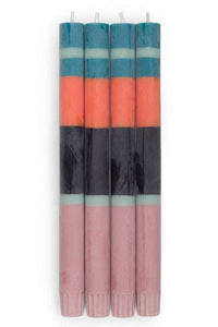 Set of four striped candles with blue, orange, and black bands on a white background