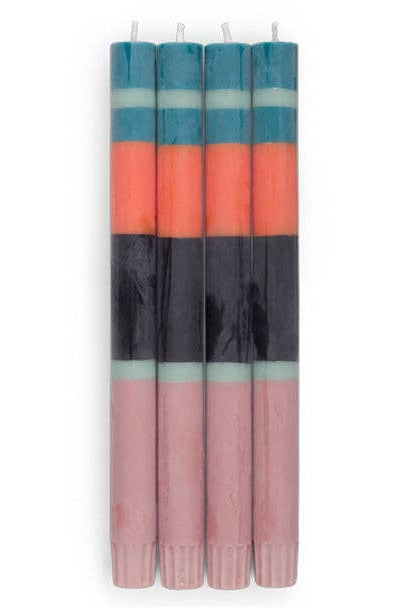Set of four striped candles with blue, orange, and black bands on a white background