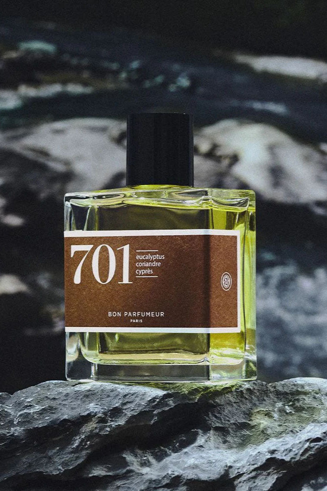 Perfume bottle labeled '701' on a dark, textured background