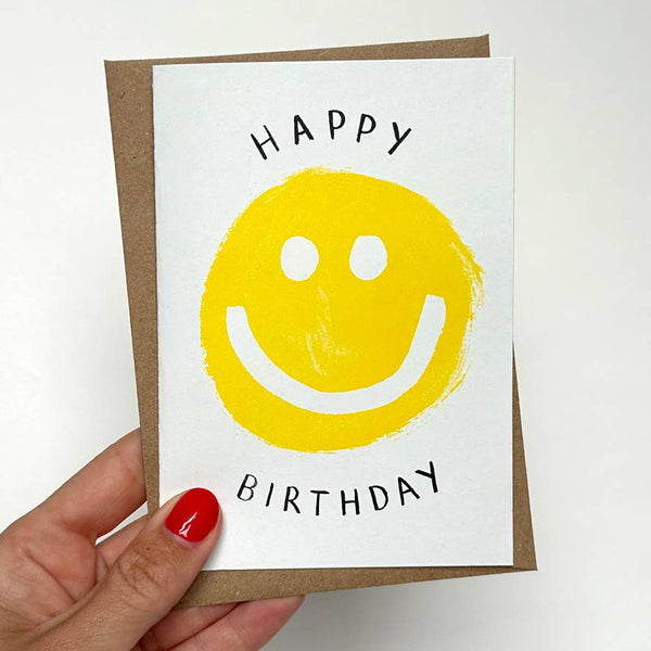 Happy Birthday card with yellow smiley face on a white background
