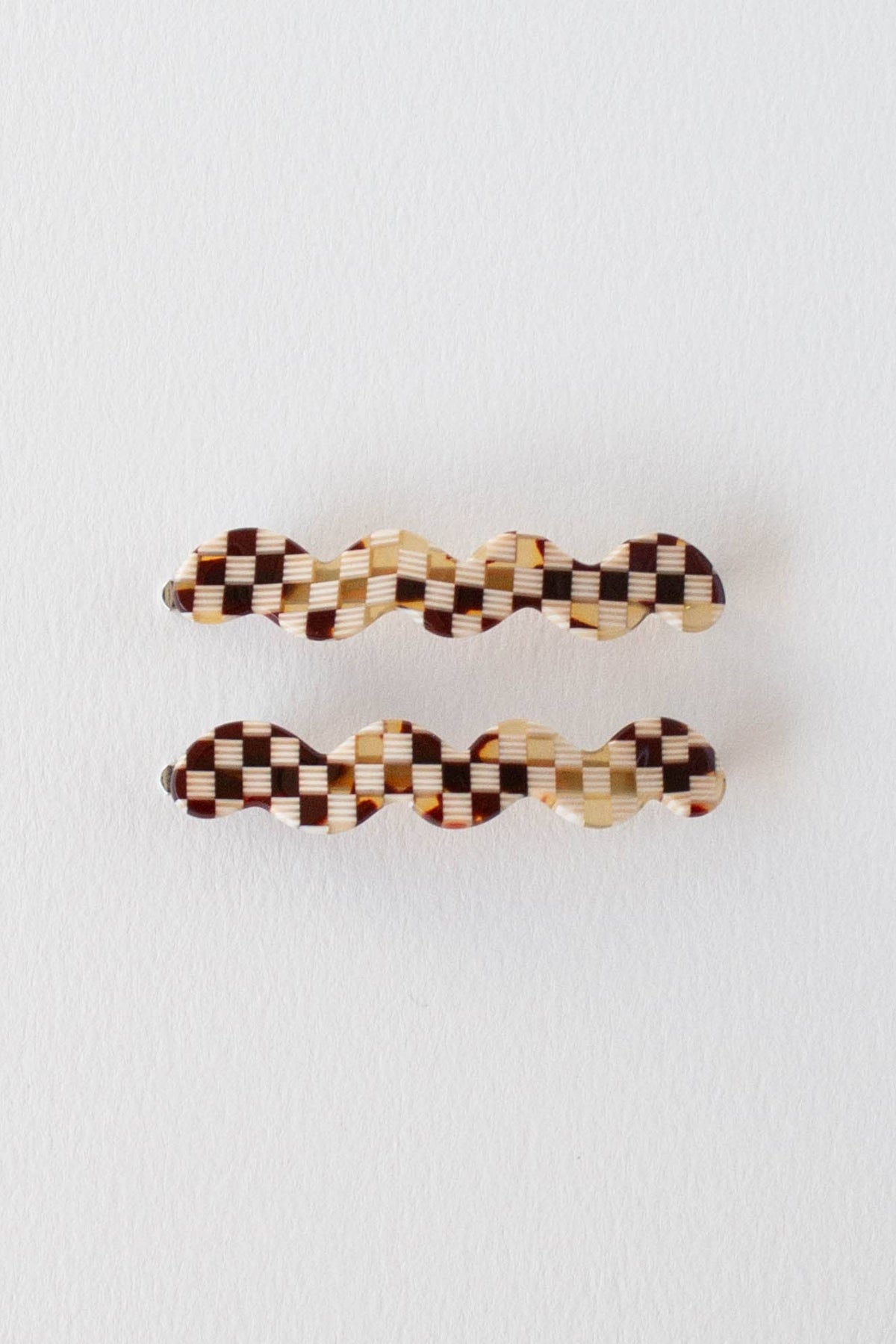 Two checkered hair clips on a white background
