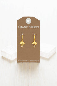 Gold earrings on a 'Amano Studio' branded card with a white background