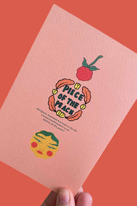 A hand holds a peach-colored textured card featuring a colorful retro illustration of a peach with the text 'MY PIECE OF THE PEACH' and a small illustrated face, set against a solid coral background.