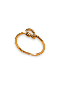 A gold-plated metal ring with a unique knotted loop design at the top, shown on a clean white background.