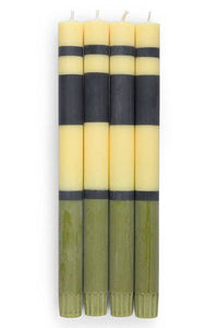 Set of four candles with alternating black and yellow stripes on a white background