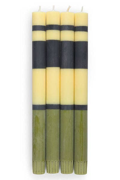 Set of four candles with alternating black and yellow stripes on a white background