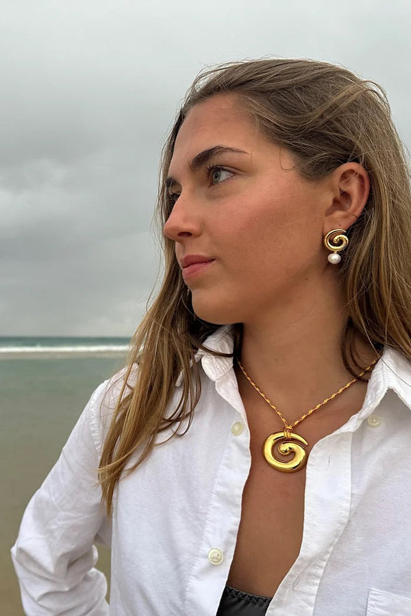 Woman wearing gold jewelry on a beach
