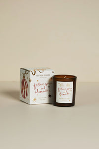 Plum & Ash candle with packaging on a beige background