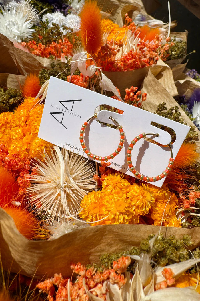 Earring set on a card with flowers in the background
