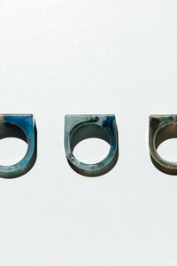Three metallic rings with a blue and silver finish on a white background