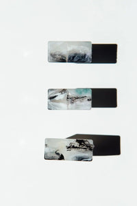 Set of four rectangular rings with marble-like design on a white background