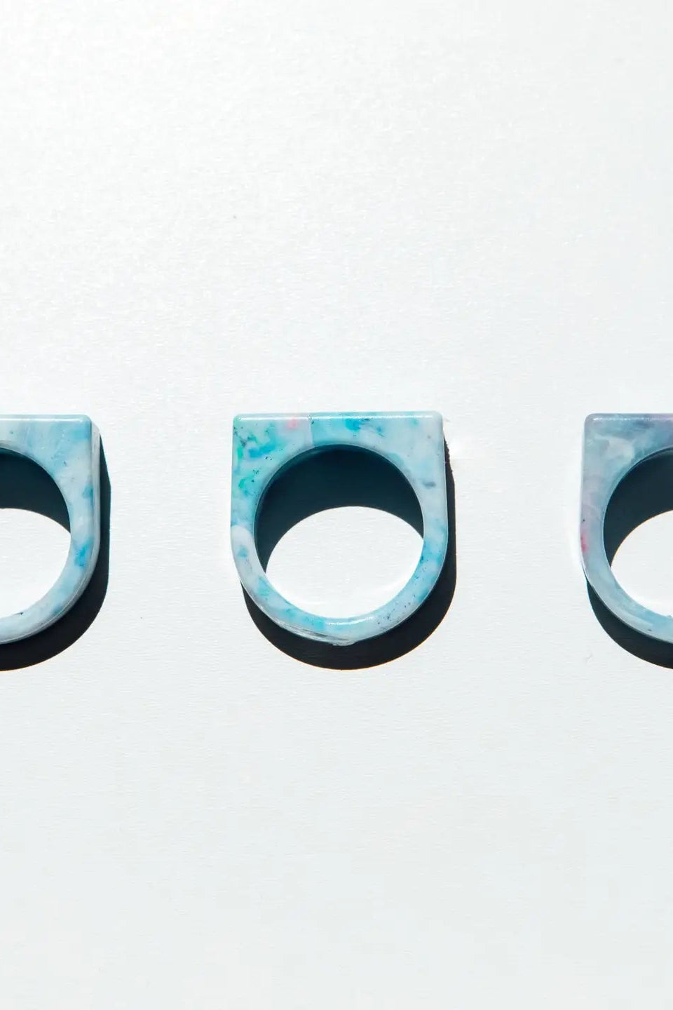 Three blue and black patterned rings on a white background