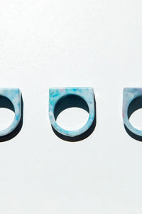 Three blue and black patterned rings on a white background