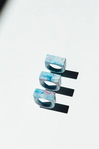 Set of three blue and white marbled rings on a light gray background