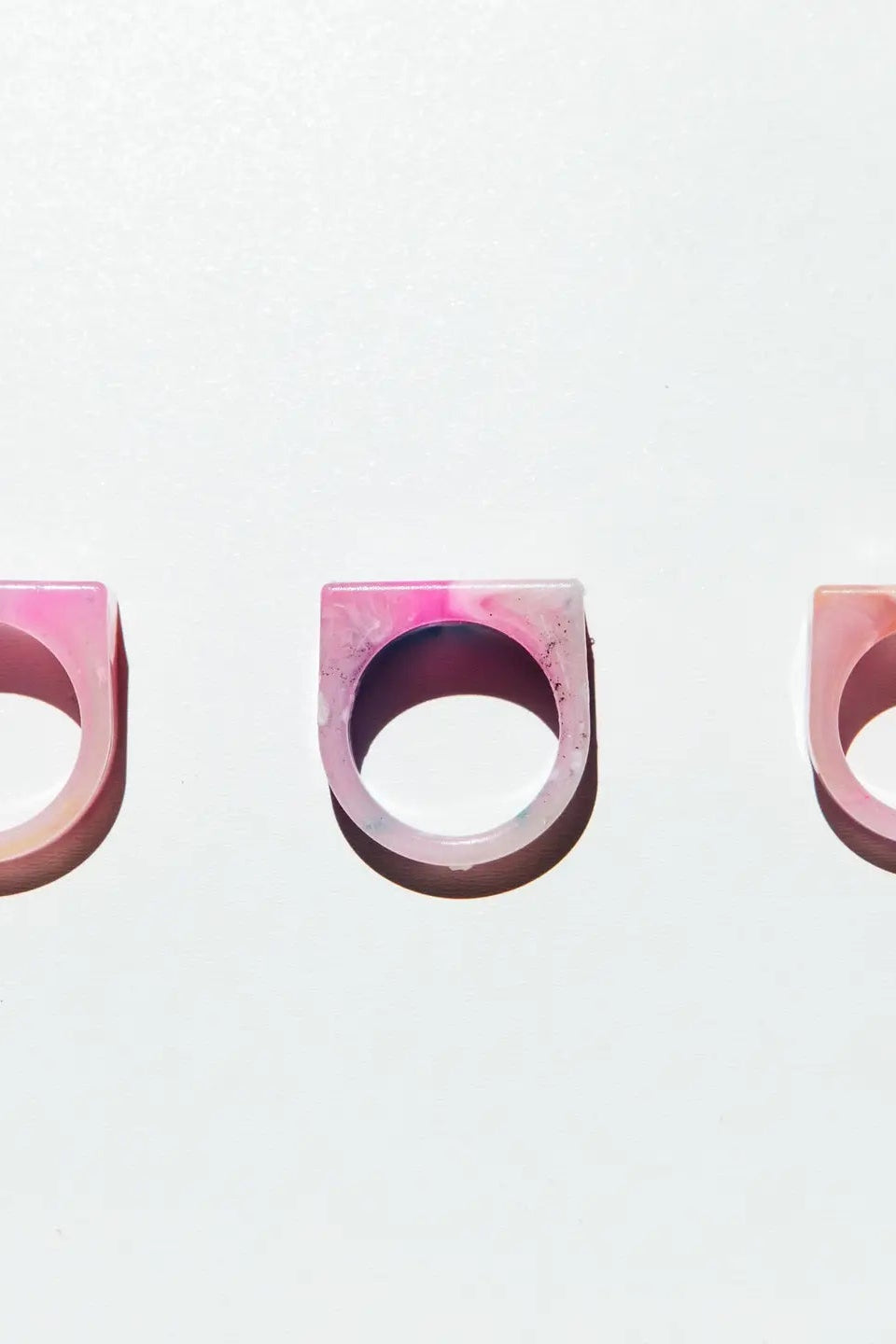 Three pink and purple gradient rings on a light gray background