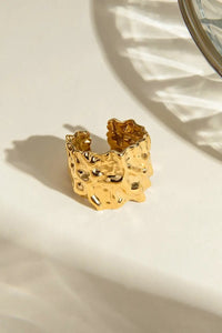 Gold textured ring on a light surface with a mirror reflection
