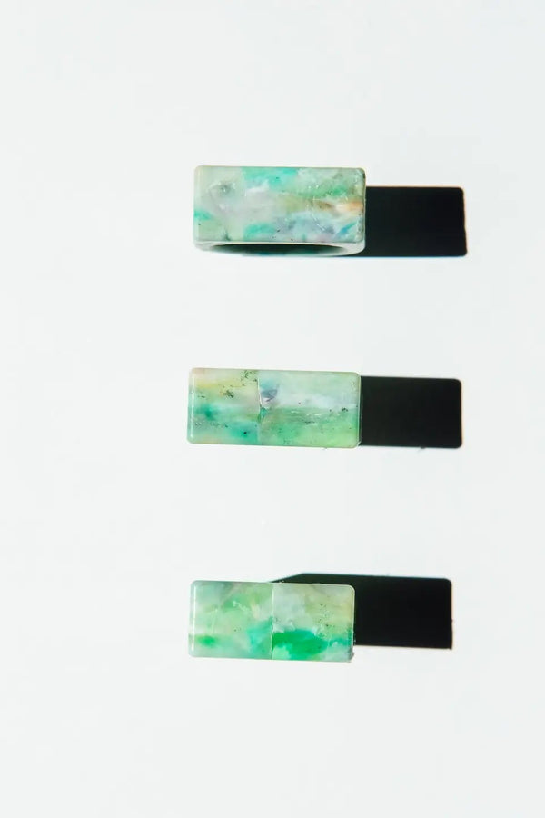 Set of three rectangular rings with a marbled green design on a white background