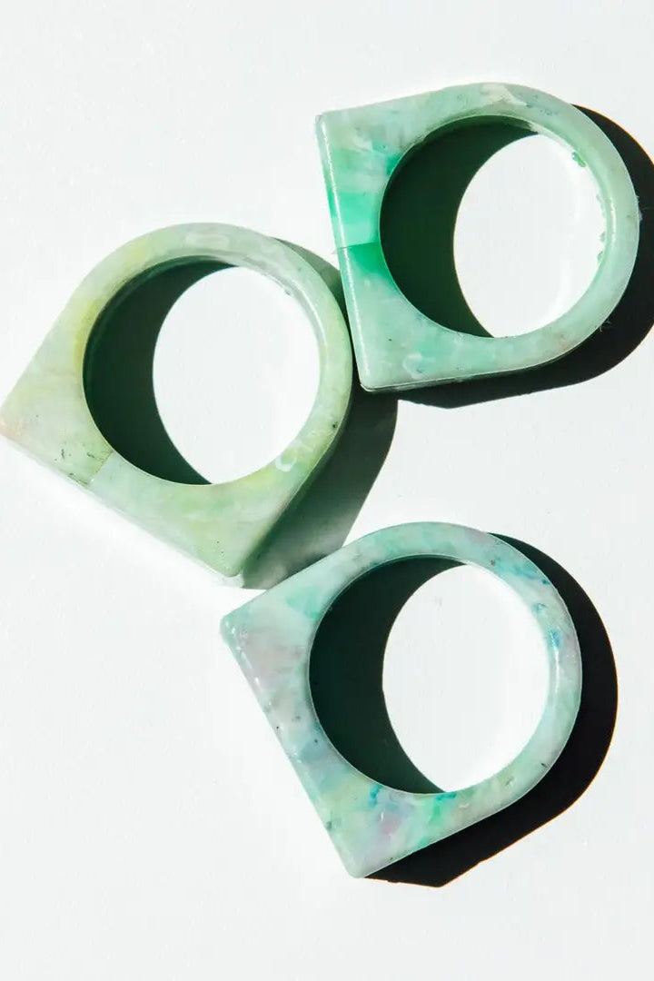 Three green marble-patterned rings stacked on a white background