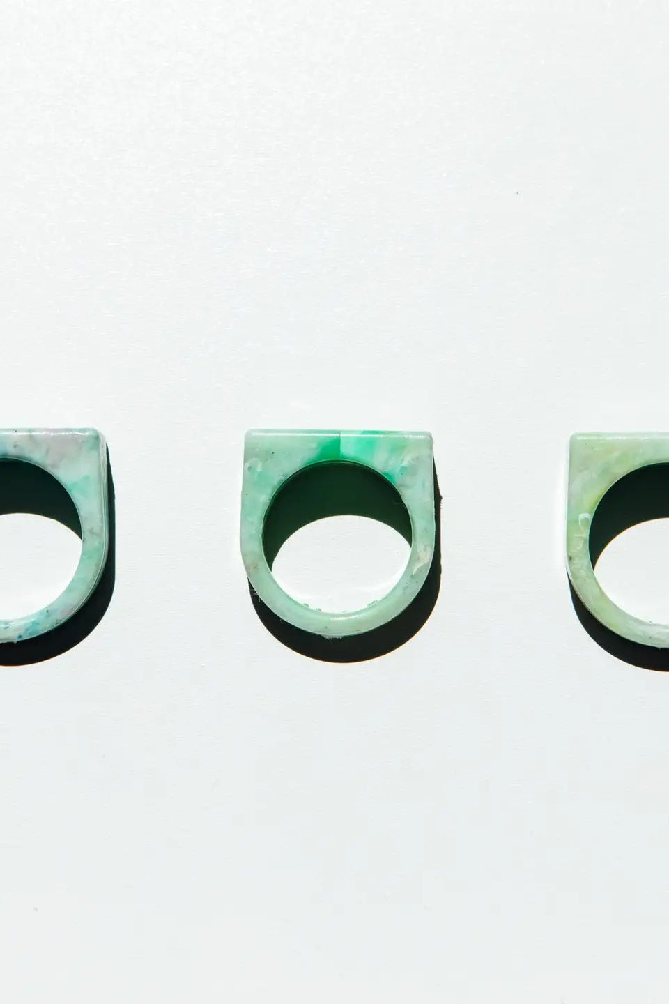 Three green rings on a light gray background