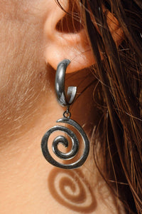 Close-up of a person wearing a silver spiral earring.