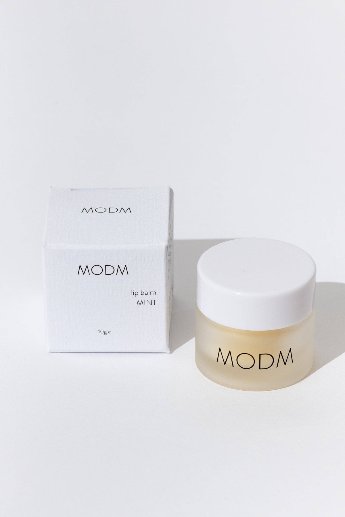 MODM lip balm and packaging on a white background