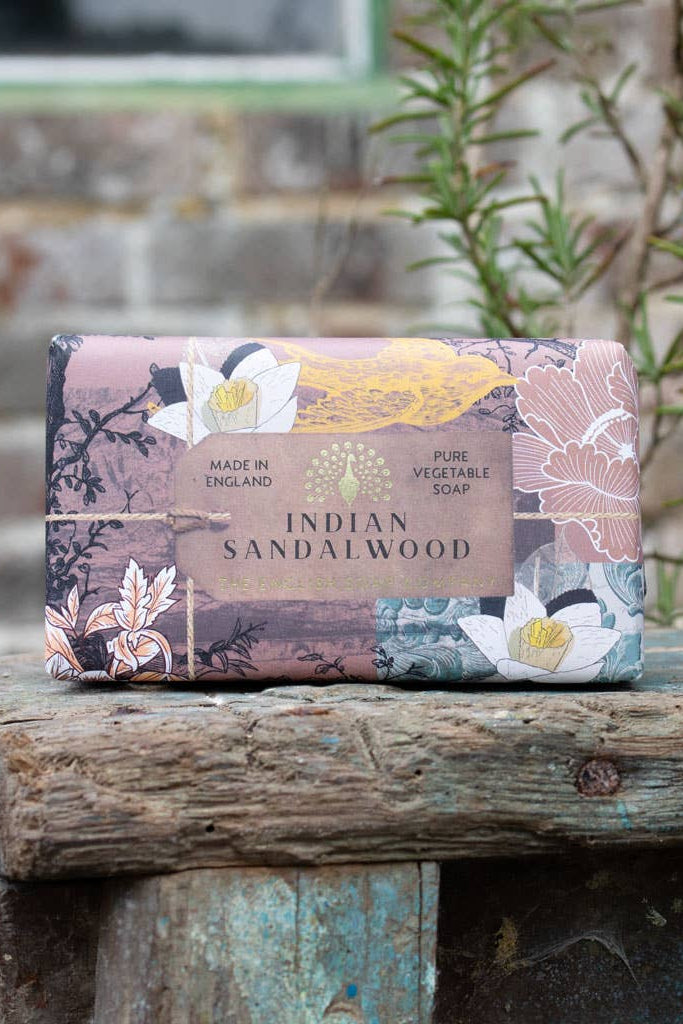 Bar of soap with floral packaging on a wooden bench outdoors