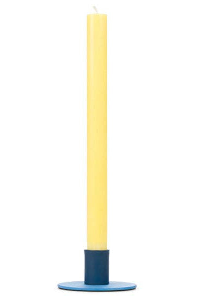 Yellow candle on a blue base against a white background