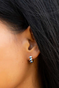 Close-up of an ear with a silver earring against a blurred background