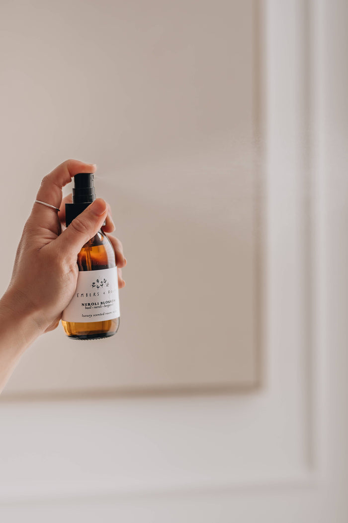 Hand holding a bottle with a label against a plain background