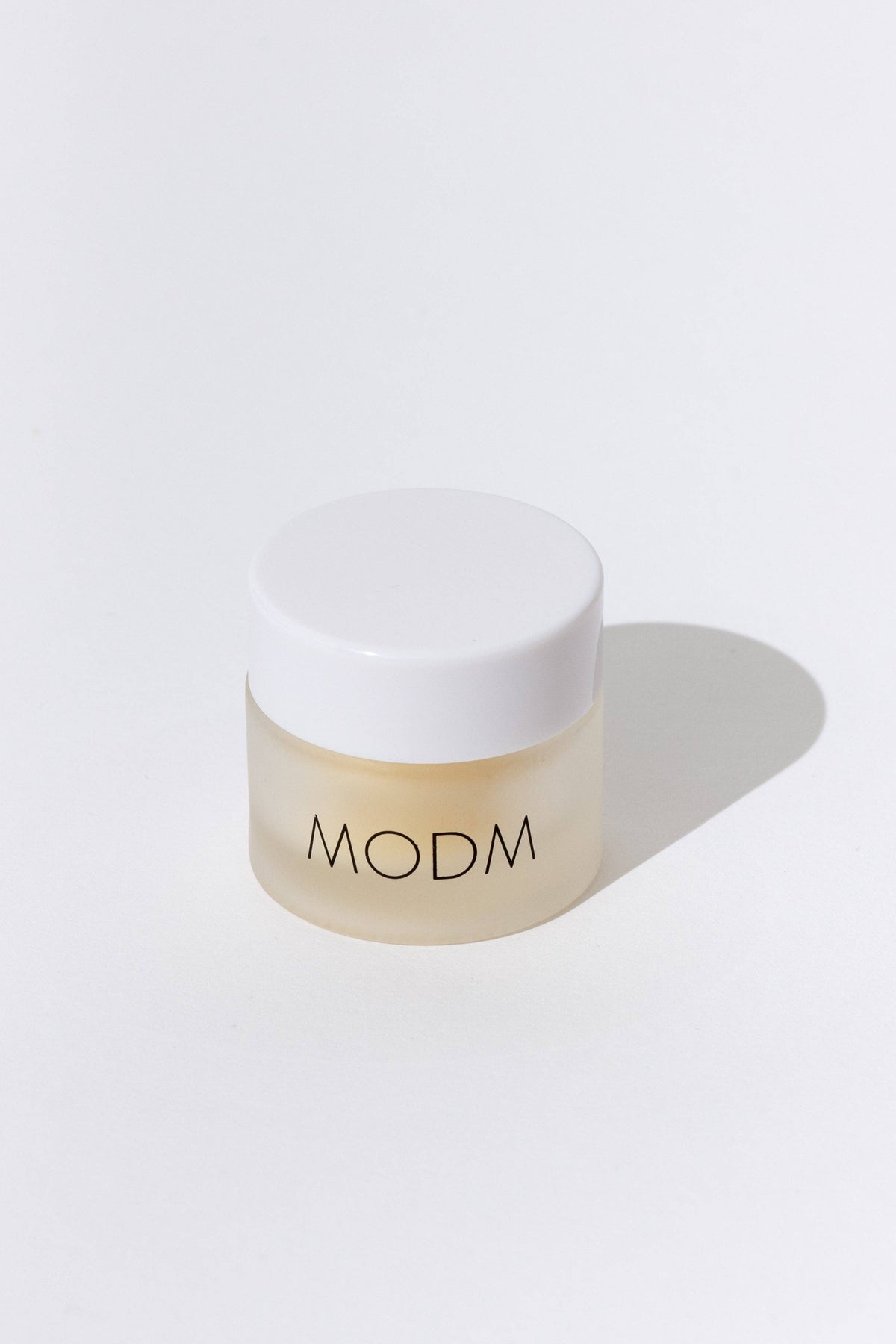 Beige jar with white lid on a light gray background