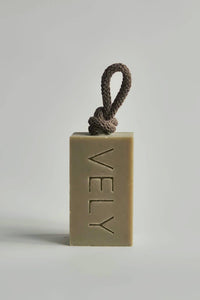 Bar of soap with a rope on a gray background, branded 'VELY'.