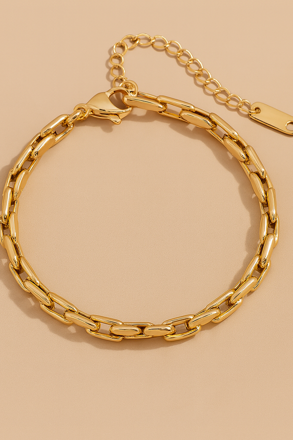 Gold chain bracelet on a beige background