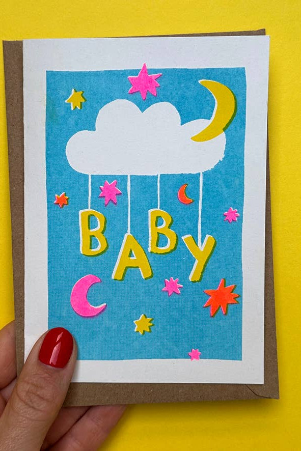 Colorful baby shower card with clouds, stars, and the word 'Baby' on a yellow background.