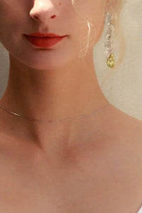 Woman wearing a white tank top with a neutral background