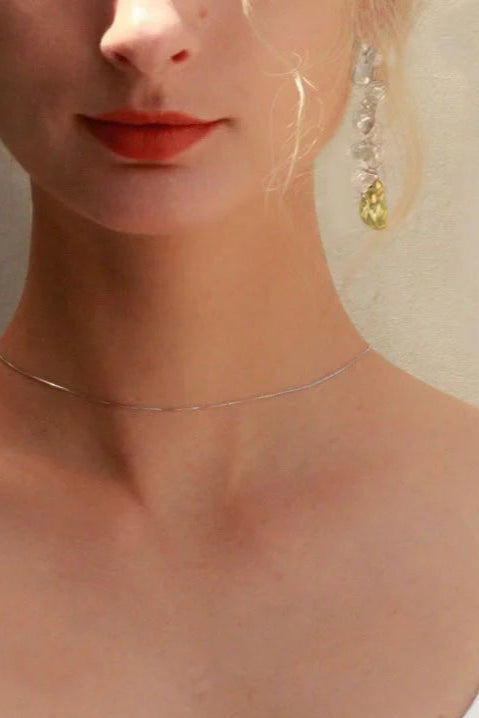 Woman wearing a white tank top with a neutral background