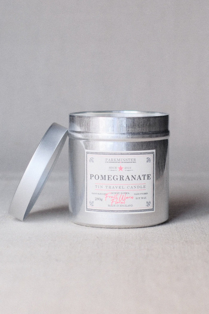 Silver candle jar with a label on a light gray background