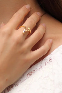 Close-up of a hand wearing a gold ring with a blurred background